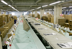 店舗別仕分け、箱詰め、出荷の工程でリニソートシステムを活用